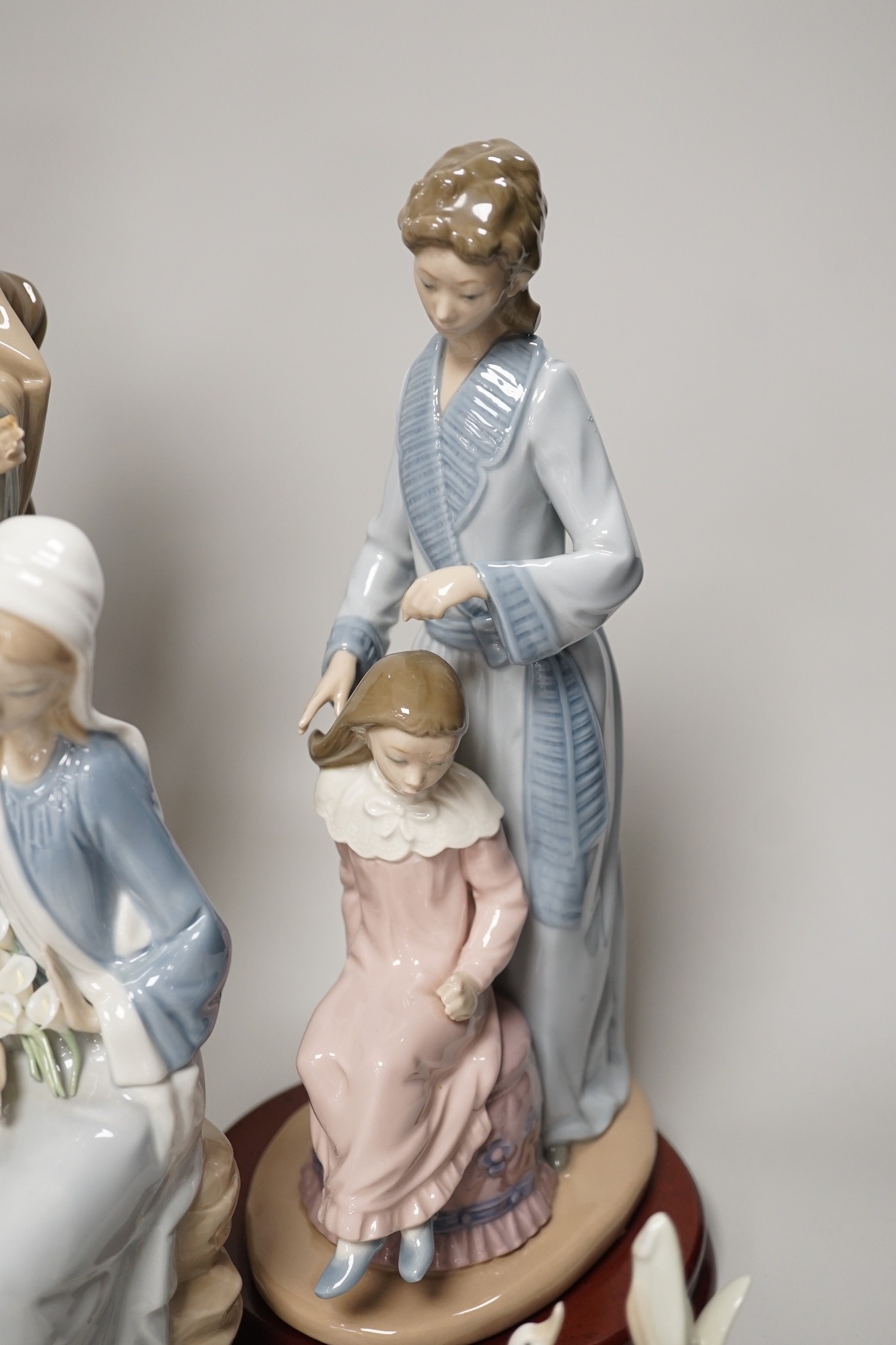 Seven Lladro and two Nao porcelain figures together with another, stuck to base so mark can’t be seen. Tallest 38cm